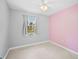 Charming bedroom with grey and pink walls, carpet flooring and a ceiling fan at 2143 Starlite Ln, Port Charlotte, FL 33952