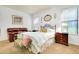 Bright bedroom with a queen-size bed, sitting area, and ample natural light at 11103 Batello Dr, Venice, FL 34292