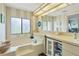 Bathroom featuring a bathtub, vanity, and large mirror at 107 Tahitian Way, North Port, FL 34287