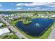 Aerial view of community lake, landscaping, and clubhouse at 107 Tahitian Way, North Port, FL 34287