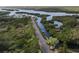 Aerial view of waterfront property with lush landscape and kayaks at 107 Tahitian Way, North Port, FL 34287