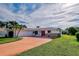 Single-story home featuring a red door and a large driveway at 1708 Shoals Ct, Venice, FL 34293