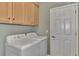 Bright laundry room, featuring washer, dryer, and ample cabinetry at 20193 Pezzana Dr, Venice, FL 34292
