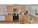 Bright kitchen with granite counters, stainless steel sink, and wood cabinets at 20193 Pezzana Dr, Venice, FL 34292
