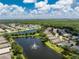 Aerial view of a house near a lake with fountain at 24849 Pennington Ter, Venice, FL 34293