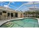 Inviting kidney-shaped pool with screened enclosure and patio furniture at 612 Albee W Rd, Nokomis, FL 34275