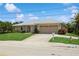 Single-story home with a tan facade and two-car garage at 612 Albee W Rd, Nokomis, FL 34275