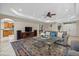 Living room with kitchen views, featuring a comfortable sofa and large TV at 8188 Shadow Pine Way, Sarasota, FL 34238