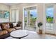 Living area with balcony access, featuring a comfortable leather couch at 1040 Gulf Winds Way, Nokomis, FL 34275