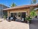 Outdoor patio with seating and glass doors leading inside at 1040 Gulf Winds Way, Nokomis, FL 34275