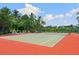 Community tennis court with lush tropical landscaping at 1040 Gulf Winds Way, Nokomis, FL 34275