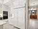 White kitchen with stainless steel appliances and a view of the entryway at 1040 Gulf Winds Way, Nokomis, FL 34275