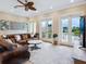 Relaxing living room with leather sofas, access to balcony, and water views at 1040 Gulf Winds Way, Nokomis, FL 34275