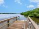 Wooden dock with bench overlooking calm water at 1040 Gulf Winds Way, Nokomis, FL 34275