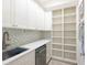 White pantry with open shelving and a built-in dishwasher at 1040 Gulf Winds Way, Nokomis, FL 34275