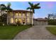 Two story house with a large driveway and palm trees at 1040 Gulf Winds Way, Nokomis, FL 34275
