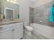 Bathroom with granite countertop, a bathtub, and grey tile at 10079 Crooked Creek Dr, Venice, FL 34293