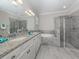 Elegant bathroom with granite vanity, a soaking tub, and a walk-in shower at 10079 Crooked Creek Dr, Venice, FL 34293