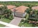 Aerial view of single-Gathering home with tile roof, driveway, and lush landscaping at 10079 Crooked Creek Dr, Venice, FL 34293