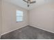 Bright bedroom with neutral walls, grey carpet, and a window with blinds at 10079 Crooked Creek Dr, Venice, FL 34293