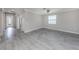 Spacious living room with gray tile flooring and access to other rooms at 10079 Crooked Creek Dr, Venice, FL 34293