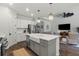 Open concept kitchen boasts a farmhouse sink, white cabinets, and views into the living area at 260 Caserta Ct, Nokomis, FL 34275