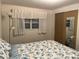 Bedroom showcasing a window with white curtains and closet doors with mirrored panel at 209 Roma Rd, Venice, FL 34285