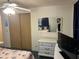 Spacious bedroom showing closet, dresser, mirror reflecting a queen sized bed and ceiling fan at 209 Roma Rd, Venice, FL 34285