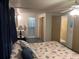 Cozy bedroom with queen bed, nightstand, and en-suite bathroom; closet and hallway entry visible at 209 Roma Rd, Venice, FL 34285