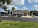 Charming single-story home with a well-maintained yard, covered parking, and mature palm trees at 209 Roma Rd, Venice, FL 34285