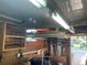 Bright garage interior featuring ample storage space, shelving, and utility area with fluorescent lighting at 209 Roma Rd, Venice, FL 34285