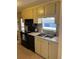 Efficient kitchen with black appliances, double sink, and ample cabinet storage space at 209 Roma Rd, Venice, FL 34285