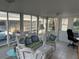 Bright sunroom featuring tile floors, white wicker furniture, and large windows at 209 Roma Rd, Venice, FL 34285