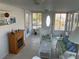 Bright sunroom featuring tile floors, white wicker furniture, and an electric fireplace at 209 Roma Rd, Venice, FL 34285