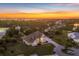 Stunning aerial view of a luxurious home nestled in a lush landscape, set against a breathtaking sunset backdrop at 2091 Marlin Way, Englewood, FL 34224