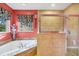 Elegant bathroom showcasing a soaking tub, a tiled shower, and a decorative window at 2091 Marlin Way, Englewood, FL 34224