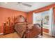 Inviting bedroom with a wooden bed, a bedside table, and a large window at 2091 Marlin Way, Englewood, FL 34224
