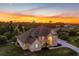 Two-story home with tile roof, arched entrance, and manicured lawn during a vibrant sunset at 2091 Marlin Way, Englewood, FL 34224