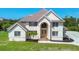 An impressive two-story home with an arched entryway, double doors, and pristine landscaping at 2091 Marlin Way, Englewood, FL 34224