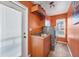 Laundry room with orange walls, a utility sink, and a front loading washer and dryer set at 2091 Marlin Way, Englewood, FL 34224