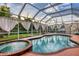 Screened-in pool area featuring a hot tub, a swimming pool, and drapery for privacy at 2091 Marlin Way, Englewood, FL 34224