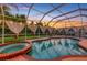 Beautiful screened-in pool area featuring a relaxing hot tub and views of the lush backyard at 2091 Marlin Way, Englewood, FL 34224