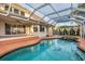 An outdoor pool area featuring a screened-in pool with tile accents, surrounded by a lounging deck at 2091 Marlin Way, Englewood, FL 34224