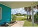 Charming home exterior featuring vibrant blue siding, tropical landscaping, and a welcoming outdoor space at 3364 Goldfinch Ln, Englewood, FL 34224