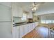 Well-lit kitchen with white cabinets, wood floors, and modern appliances at 3364 Goldfinch Ln, Englewood, FL 34224