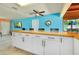 Large kitchen island with seating and white cabinets at 9027 E River Rd, Venice, FL 34293