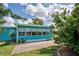 Bright teal home exterior with large windows and landscaping at 3364 Goldfinch Ln, Englewood, FL 34224