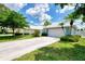 Light blue house with a white garage door and landscaped yard at 803 Harrington Lake N Dr # 75, Venice, FL 34293