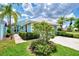 Landscaped exterior of a light blue house with lush greenery at 803 Harrington Lake N Dr # 75, Venice, FL 34293