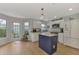 Modern kitchen with white cabinets, a blue island, and plenty of natural light at 803 Harrington Lake N Dr # 75, Venice, FL 34293